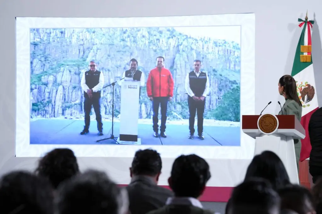 Audience watches projected outdoor press conference with officials