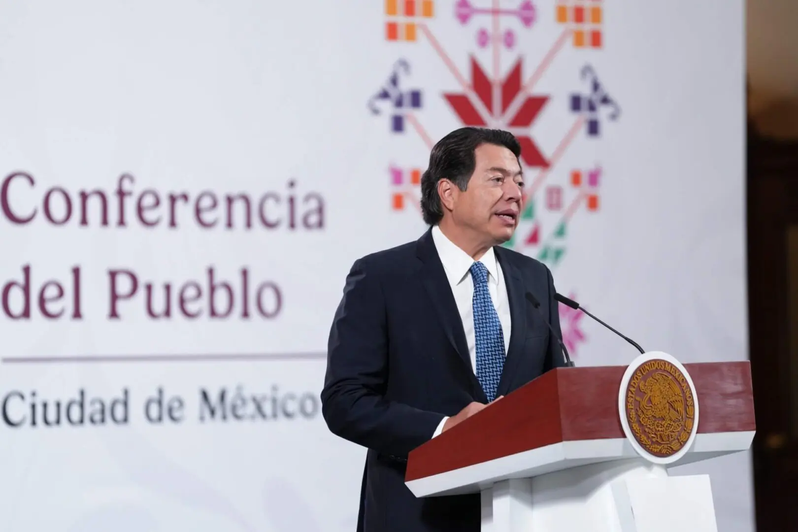 Man speaking at a podium with microphone.