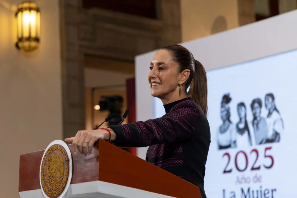 Woman speaking at podium with 2025 banner