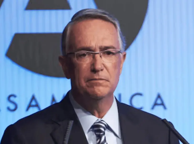 Man in suit and glasses at podium