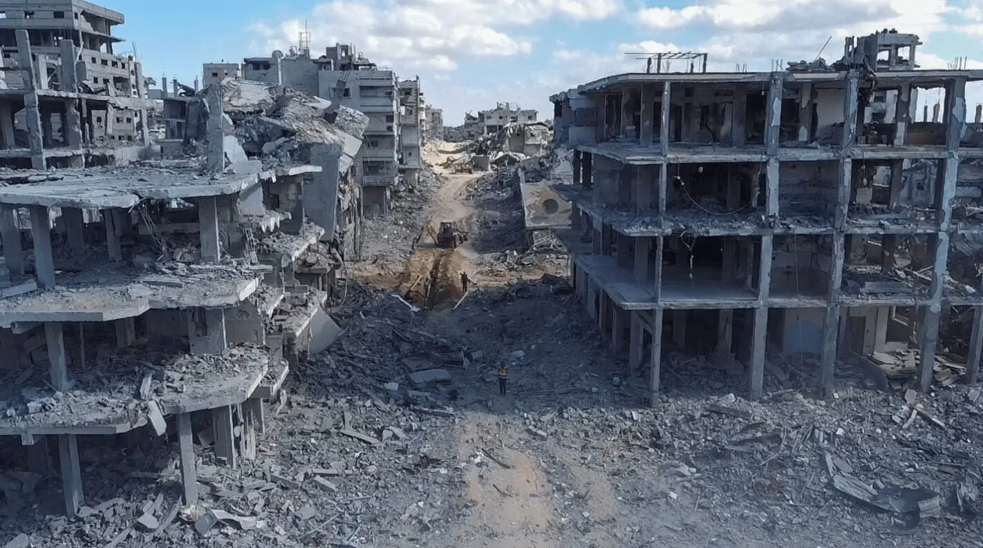 Rubble-filled street between destroyed concrete buildings