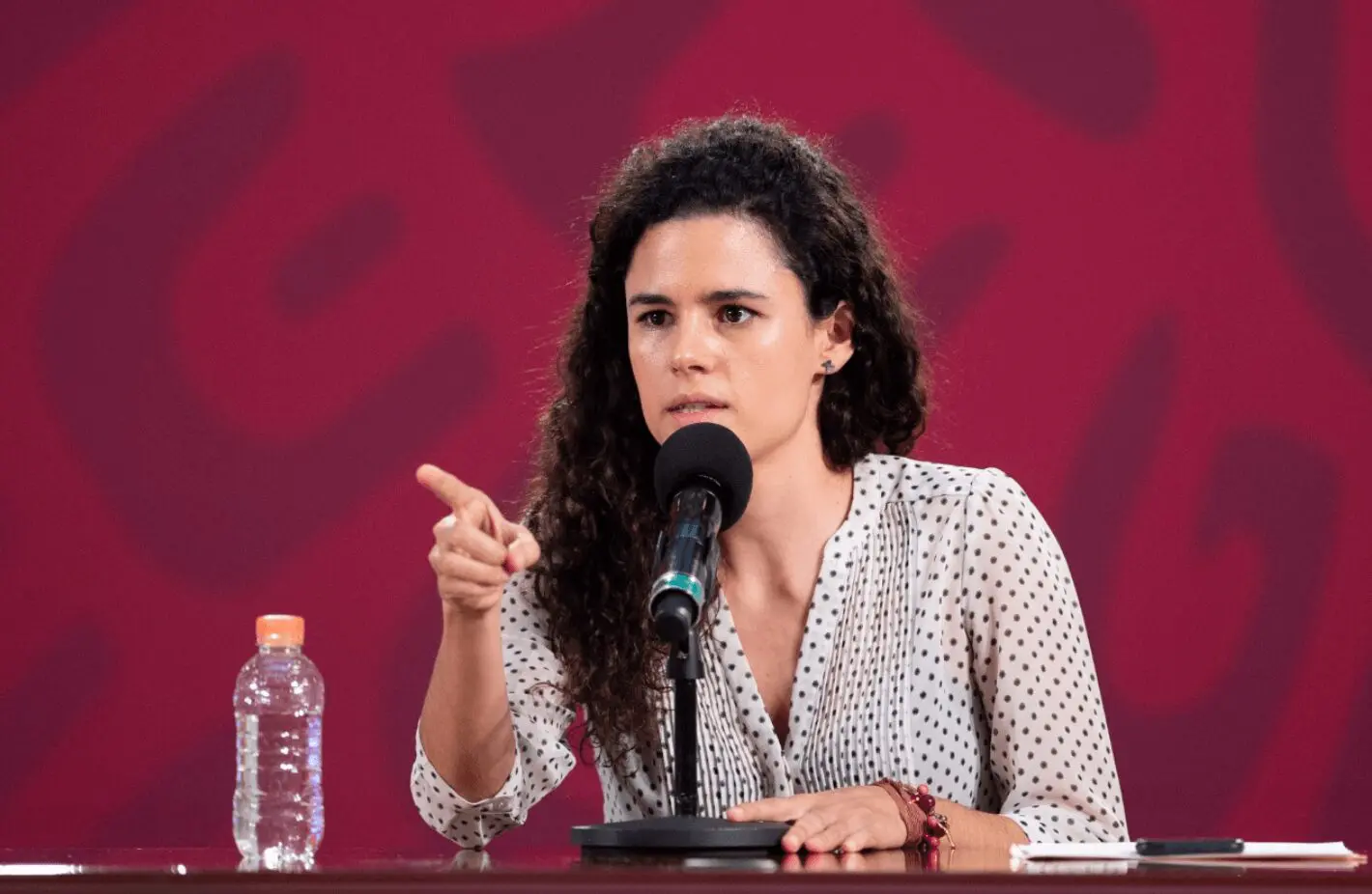 Woman pointing while speaking at press conference