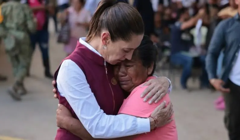 Woman comforting grieving woman in public hug