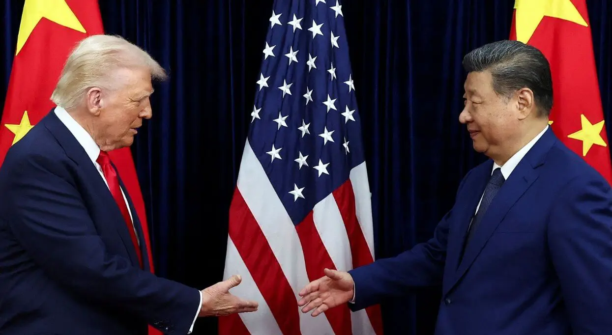 Two leaders reaching handshake beside U.S., Chinese flags