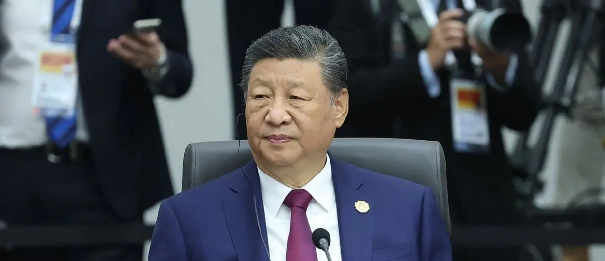 Person in suit seated at conference table