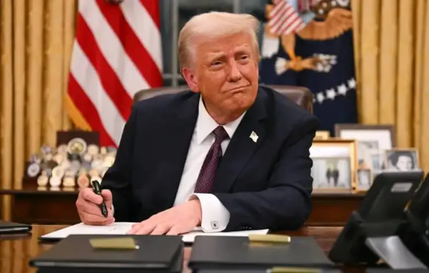 Man in suit signing papers at desk