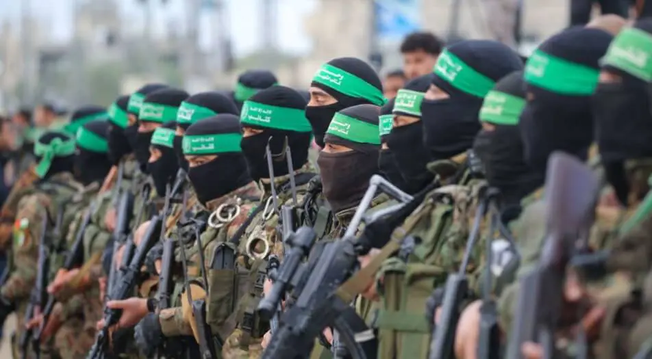 Masked armed fighters wearing green headbands