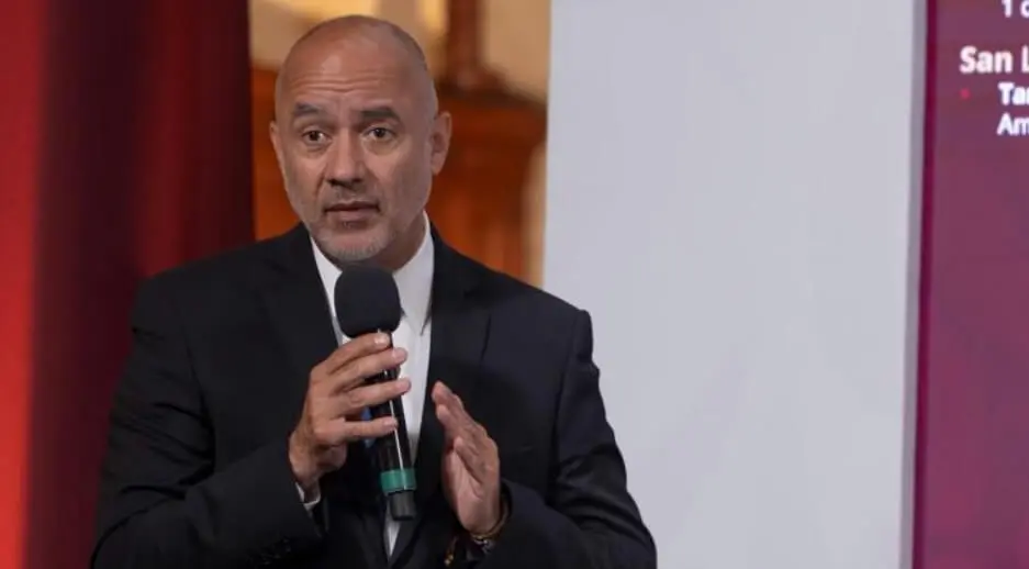 Man in suit speaking into handheld microphone