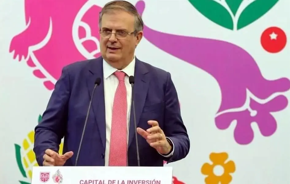 Man in suit delivering speech at colorful backdrop