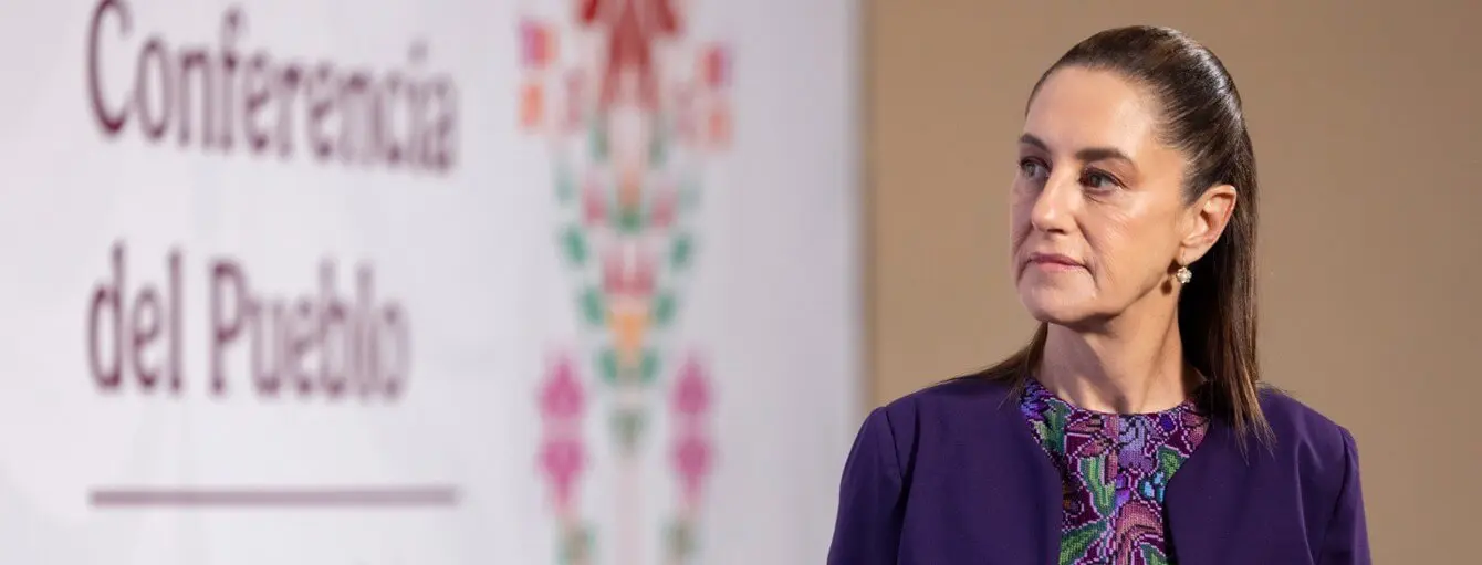 Woman listening at conference with Spanish banner