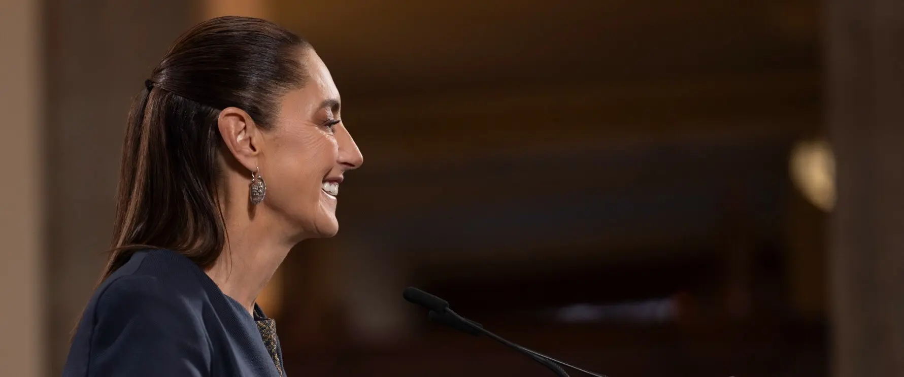 Woman smiling while speaking at podium