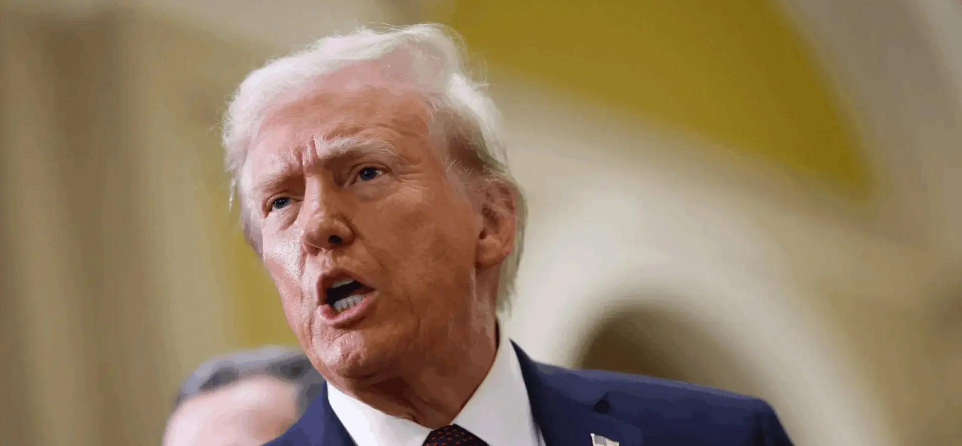 Man speaking emphatically at press event