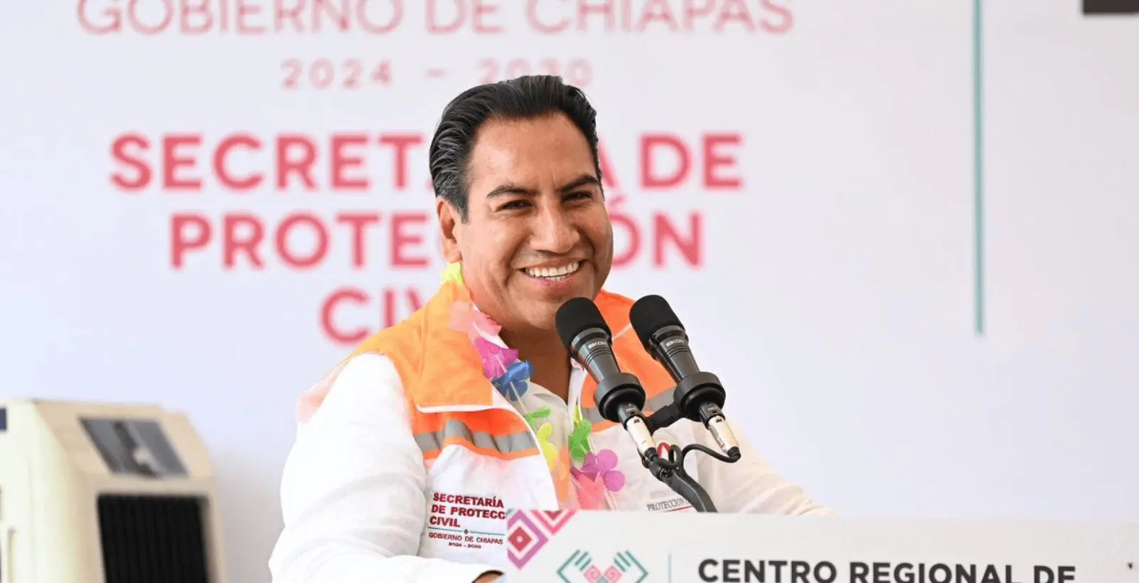 Smiling speaker at podium wearing floral scarf
