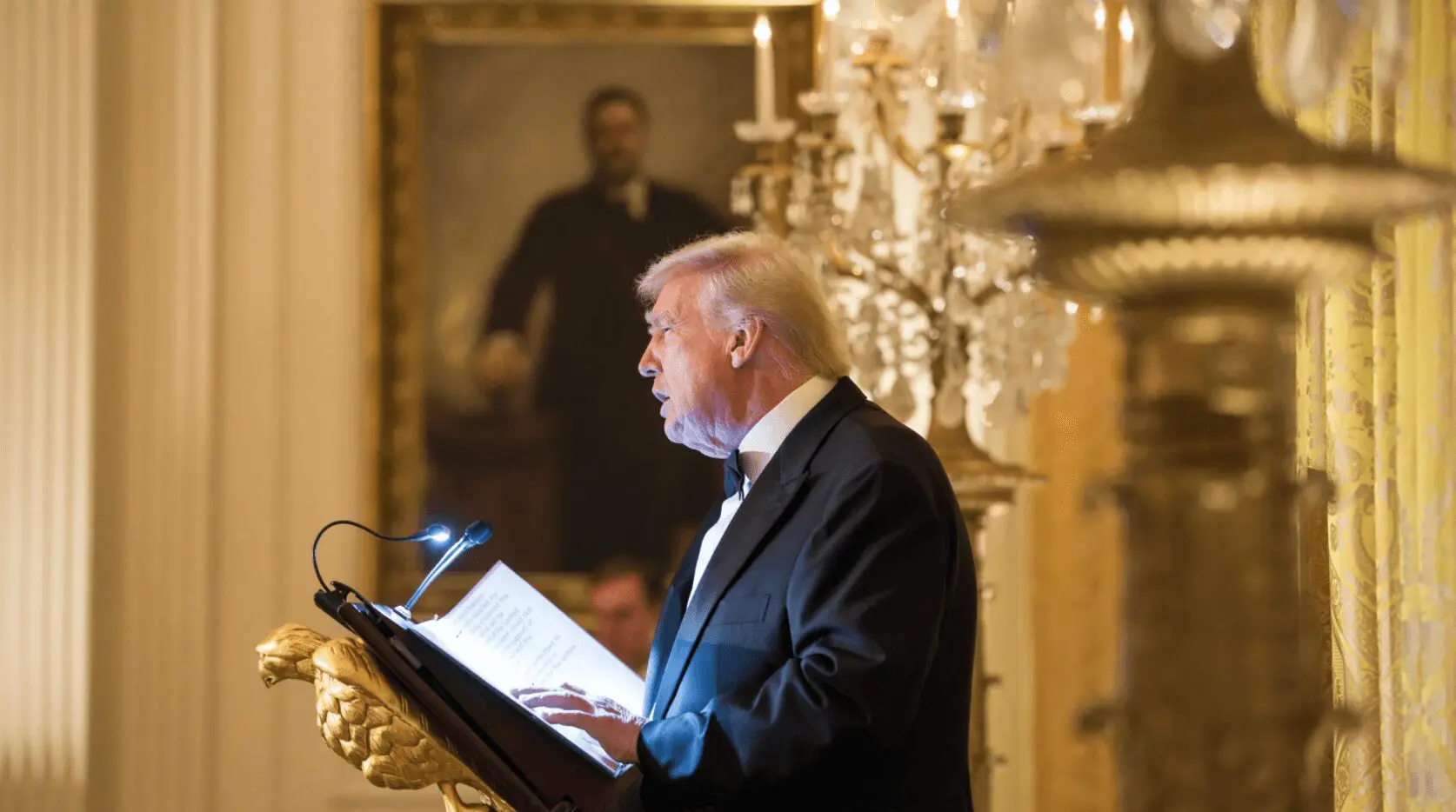 Donald Trump hablando en un podio durante un evento oficial en interiores