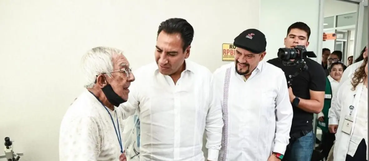 Elderly patient speaking with two men in clinic