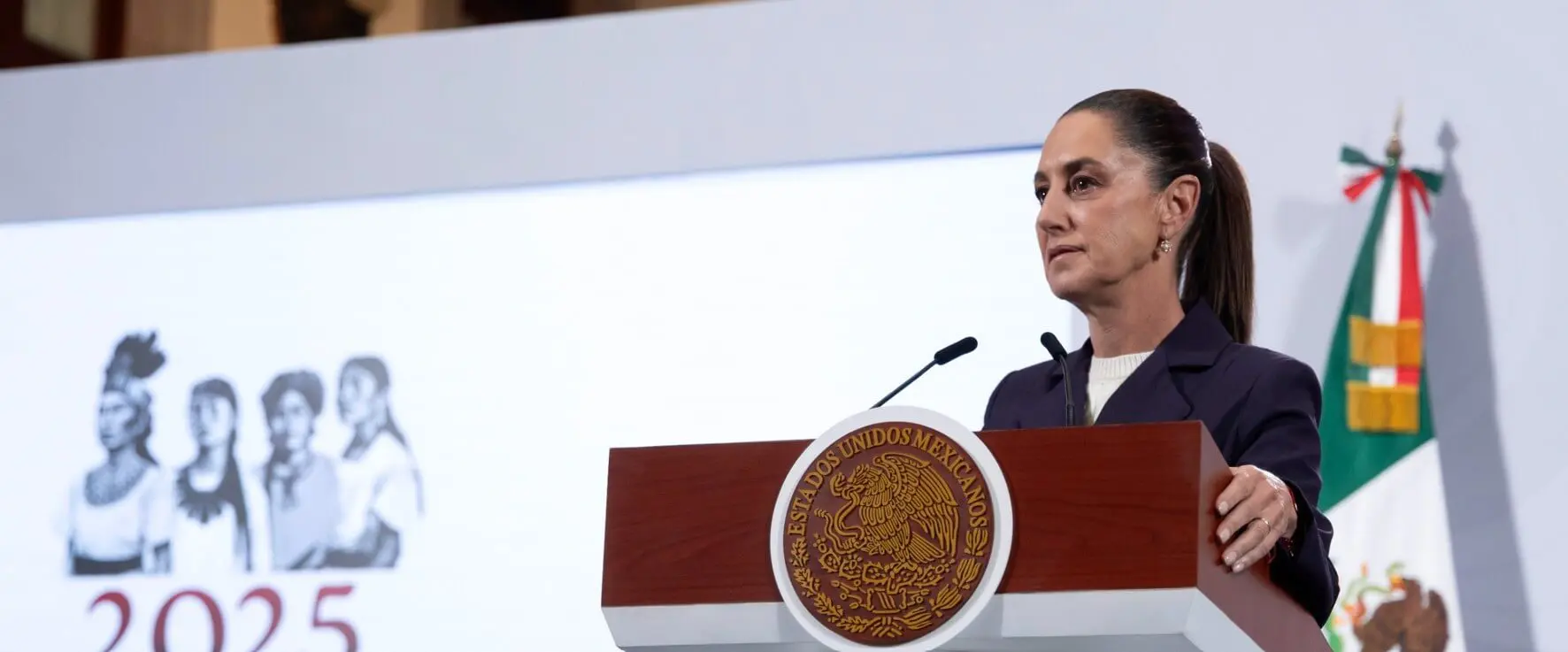 Woman speaking at presidential podium with Mexican seal