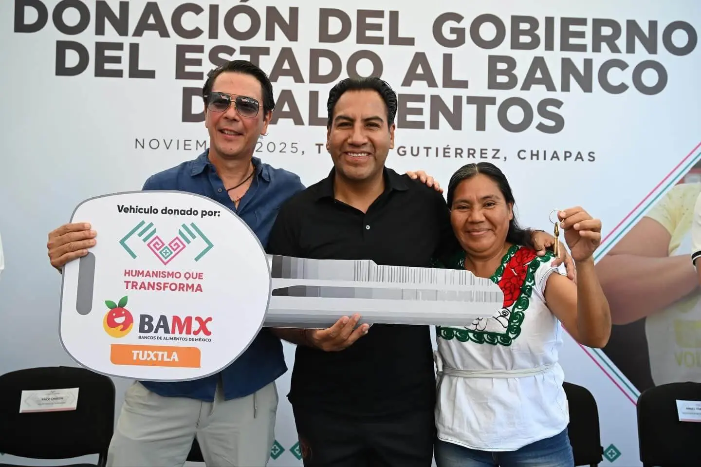 Three people with giant ceremonial key