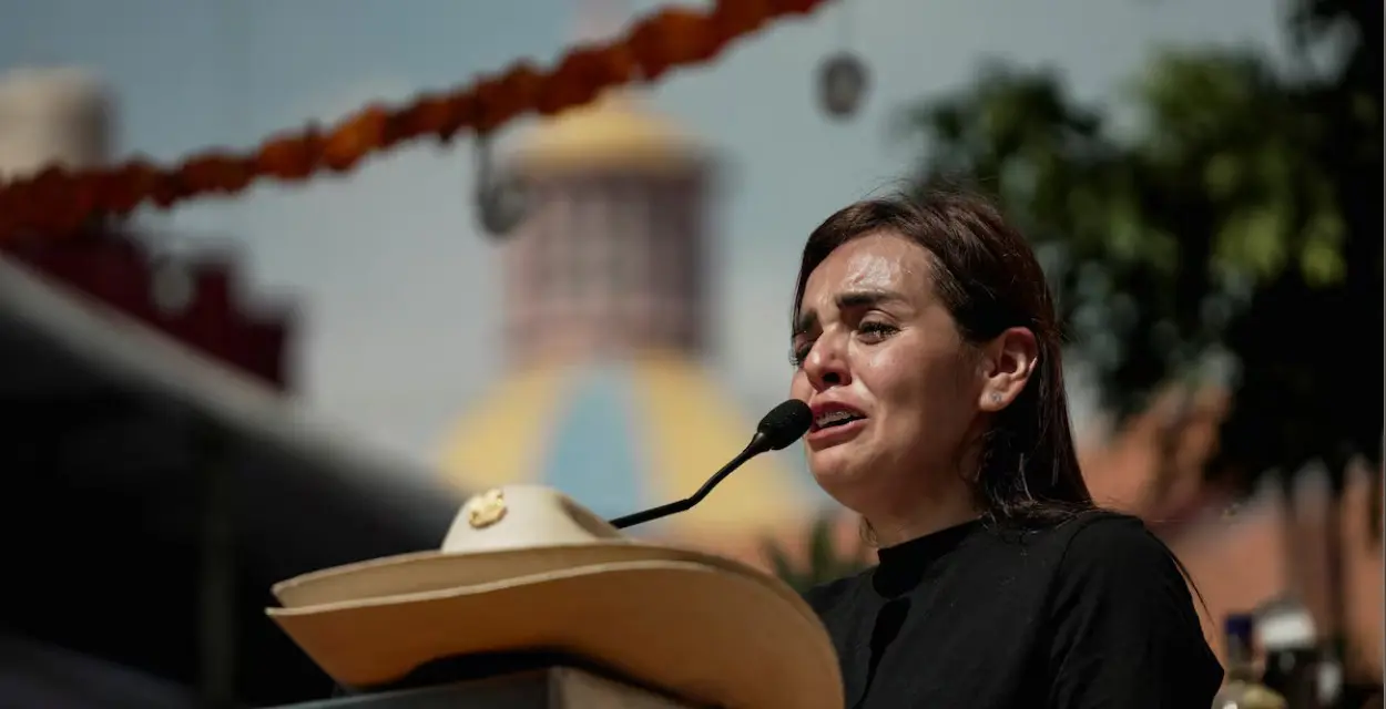 Tearful woman speaking at outdoor podium