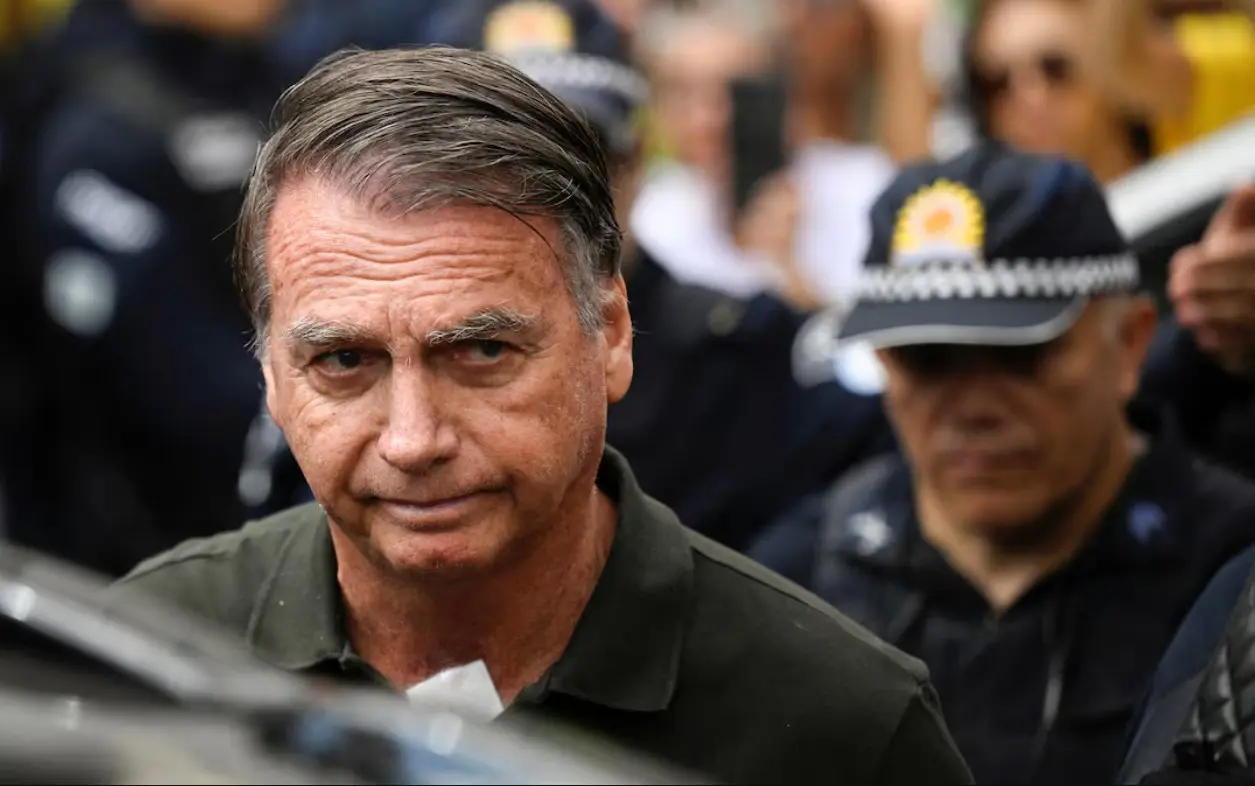 Serious man with crowd and police behind