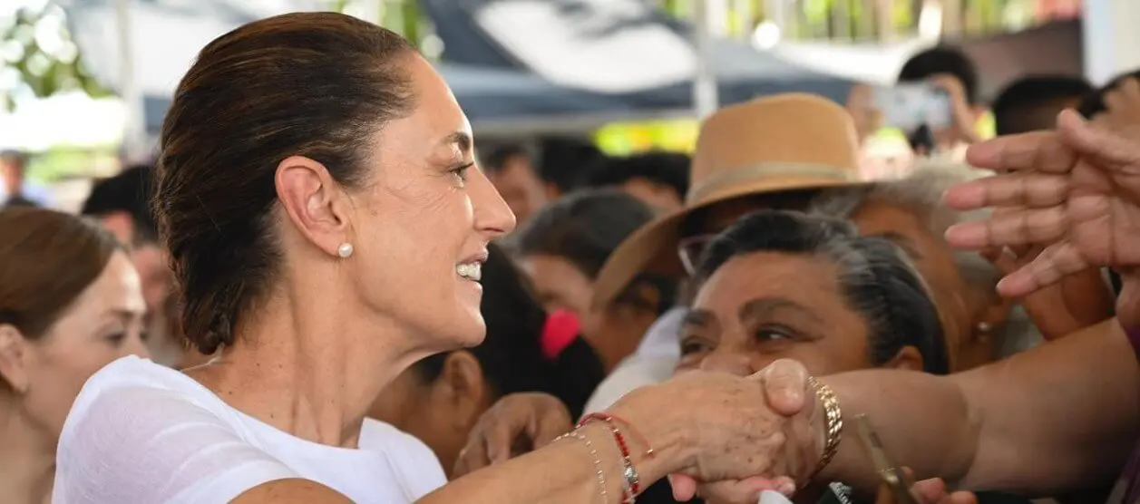 Woman warmly greeting crowd, shaking hands