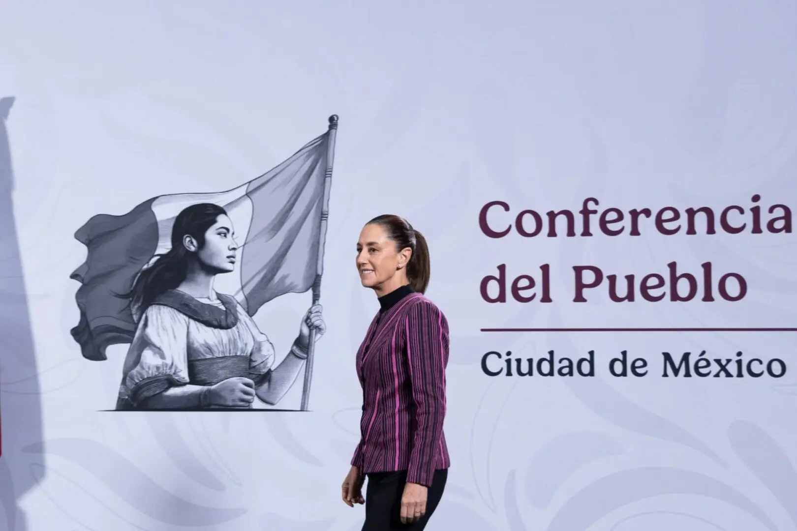 Woman walking past conference mural with flag