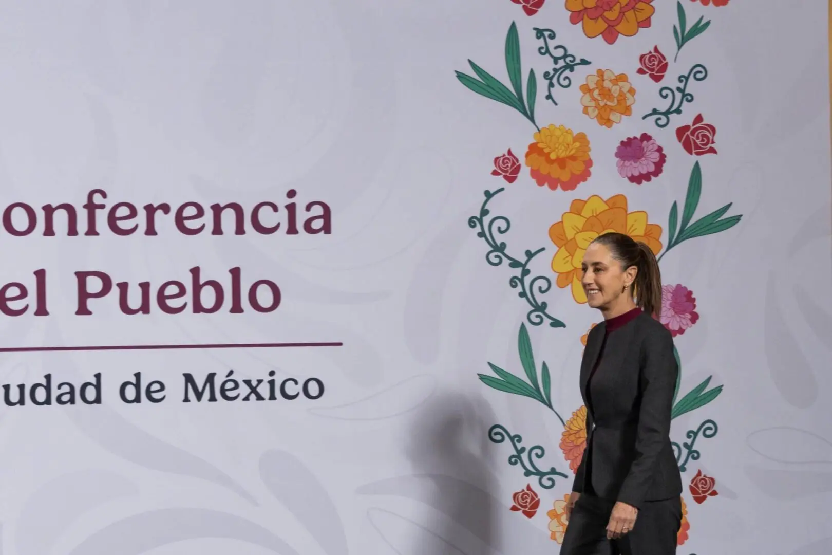Woman walking by floral conference backdrop