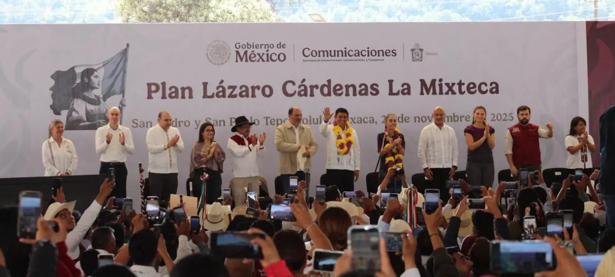 Government officials on stage, audience filming with phones