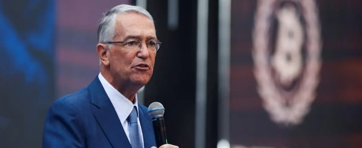 Man in suit speaking into microphone on stage