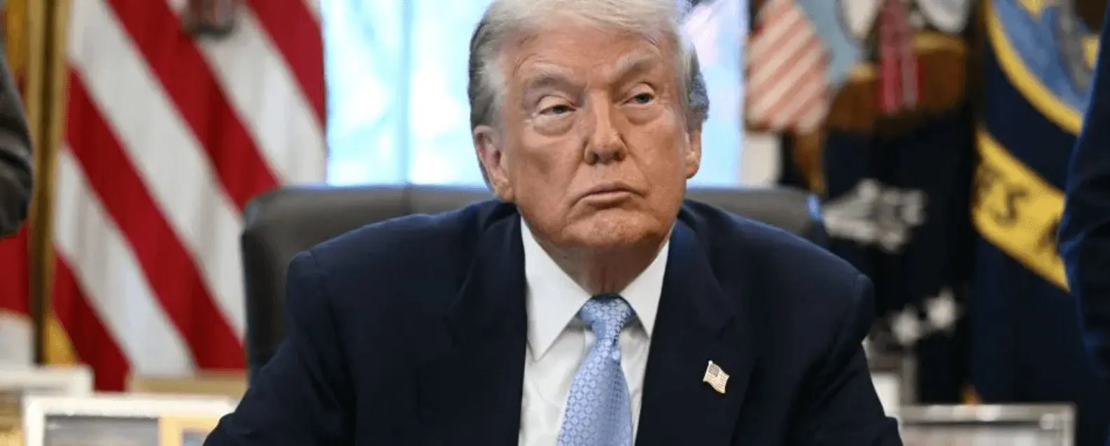 Seated man in suit with American flags