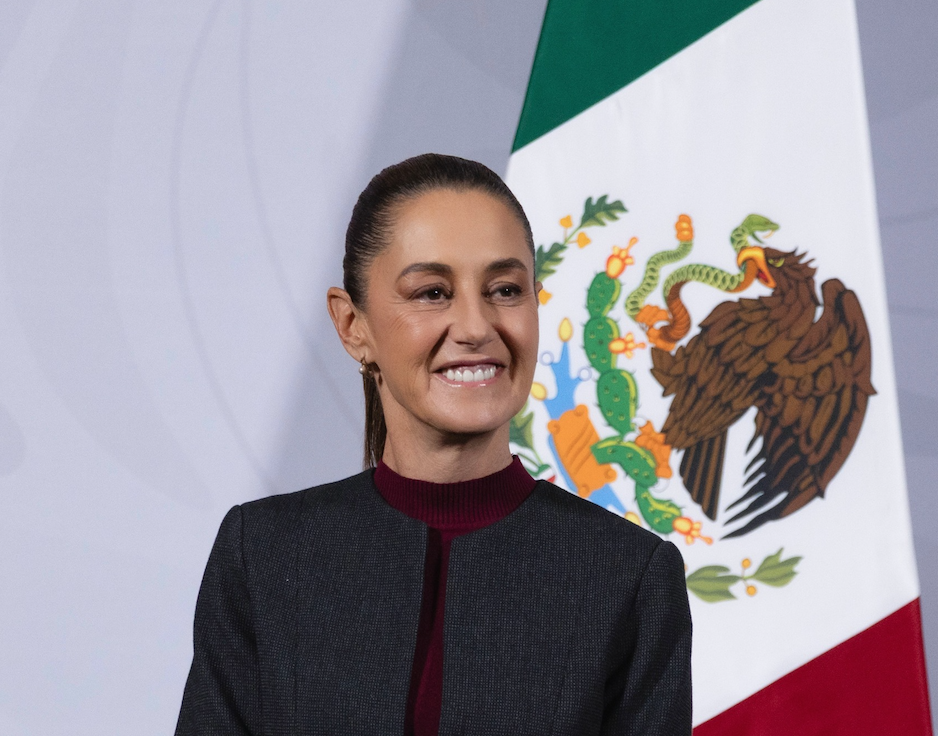 Smiling woman before Mexican flag backdrop