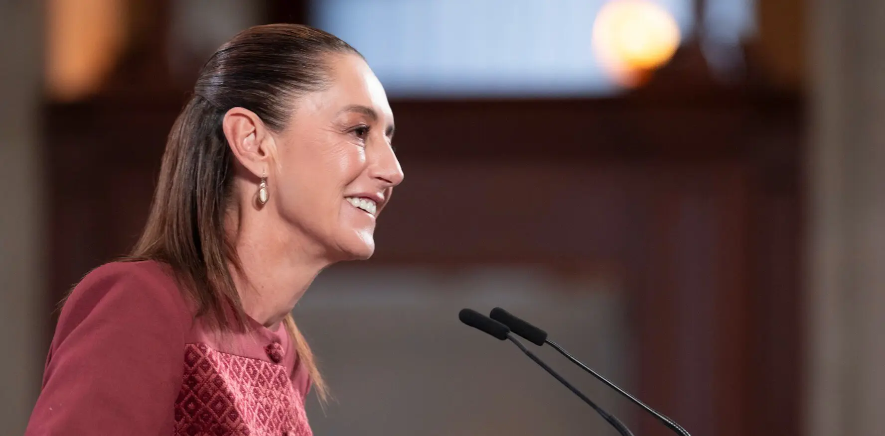 Smiling woman speaking at podium with microphones