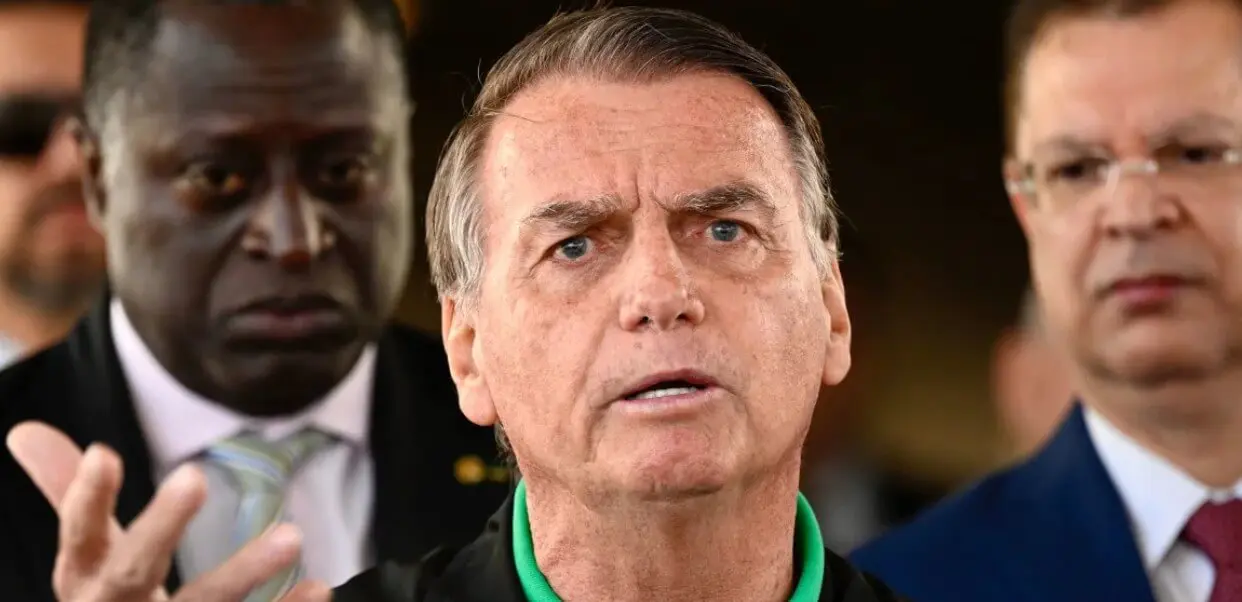 Serious man speaking with two men behind him