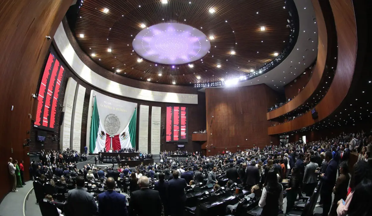 Legislative chamber with large Mexican flag