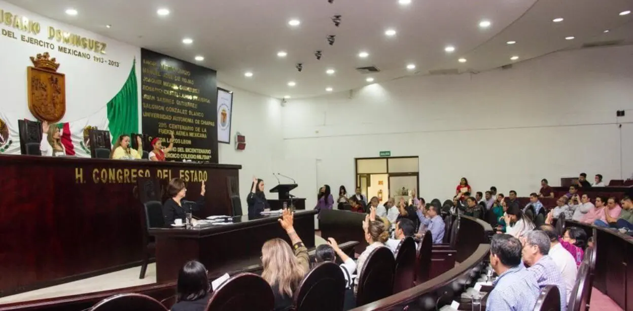 Assembly members raising hands during session