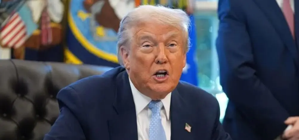 Seated older man with blond hair at desk