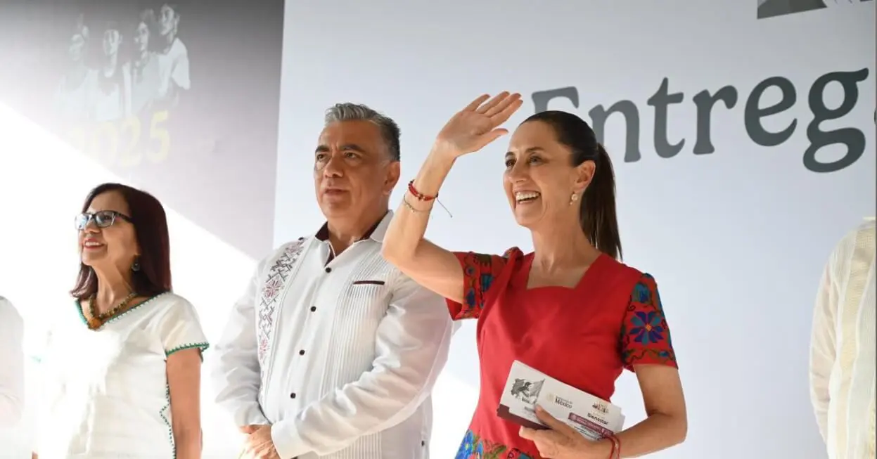 Smiling woman waving, colleagues standing at ceremony
