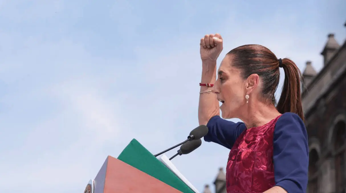 Woman speaking passionately at outdoor podium.