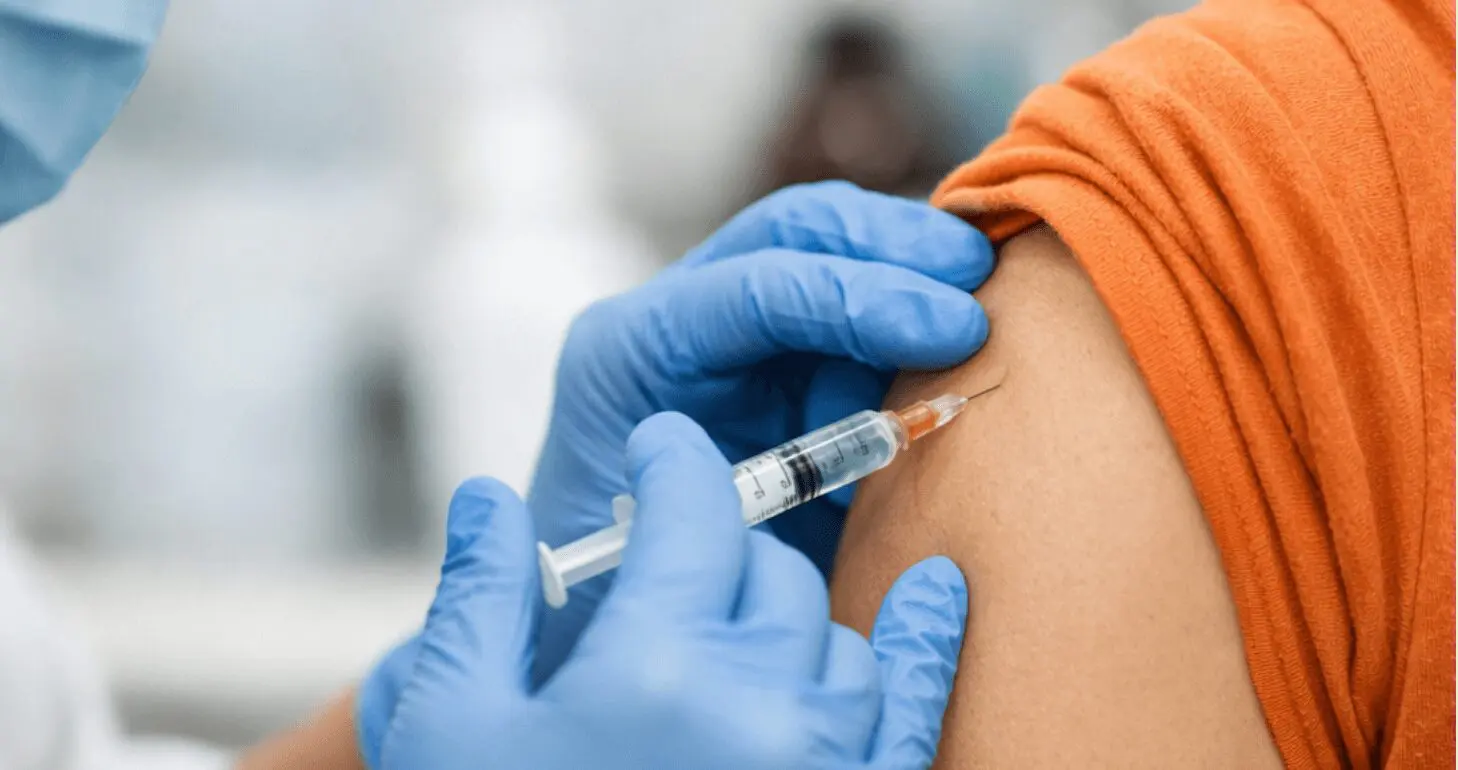 Healthcare worker administering a vaccine injection.