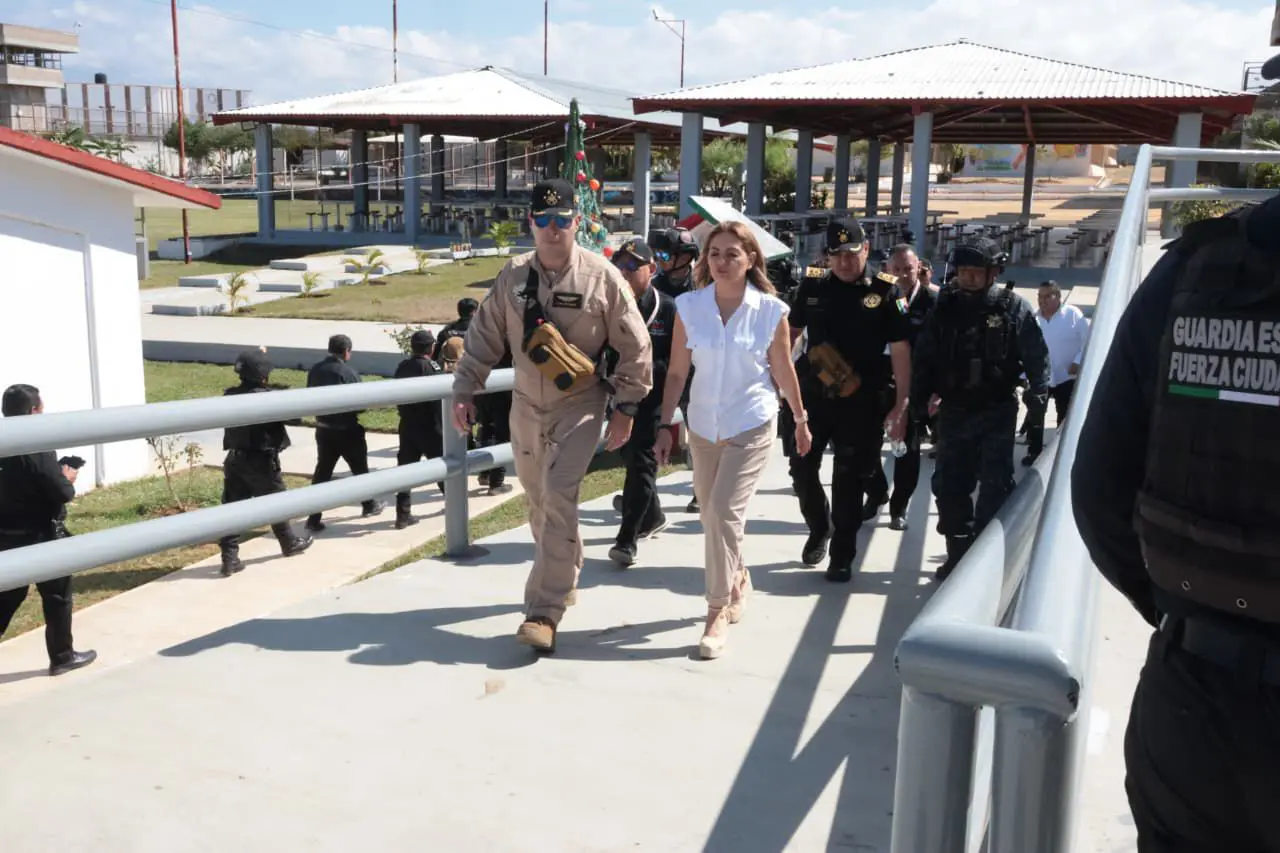 Woman escorted by uniformed officers on ramp