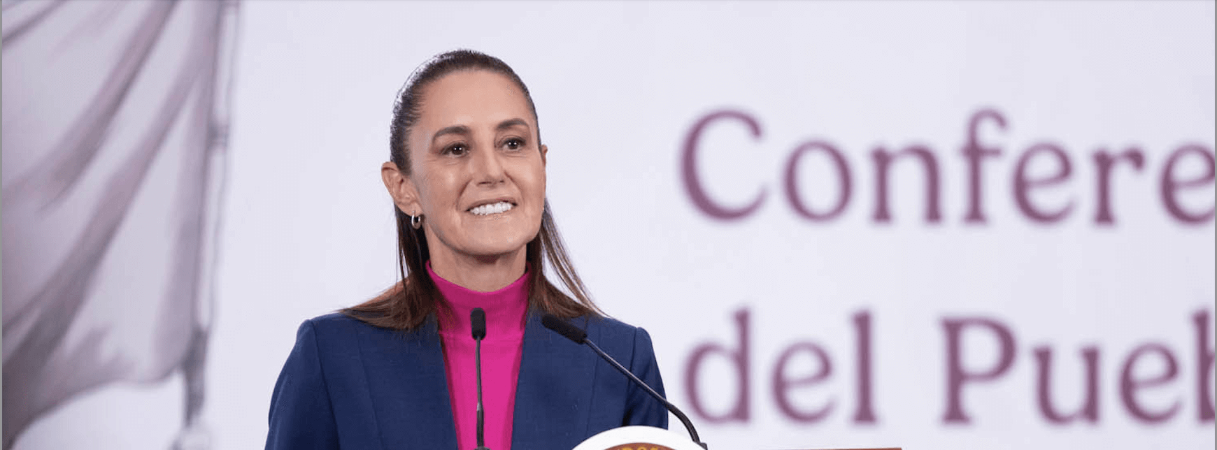 Smiling female speaker at conference podium