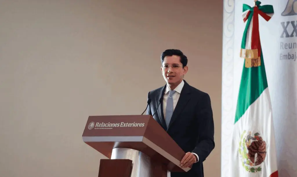 Man at podium with Mexican flag