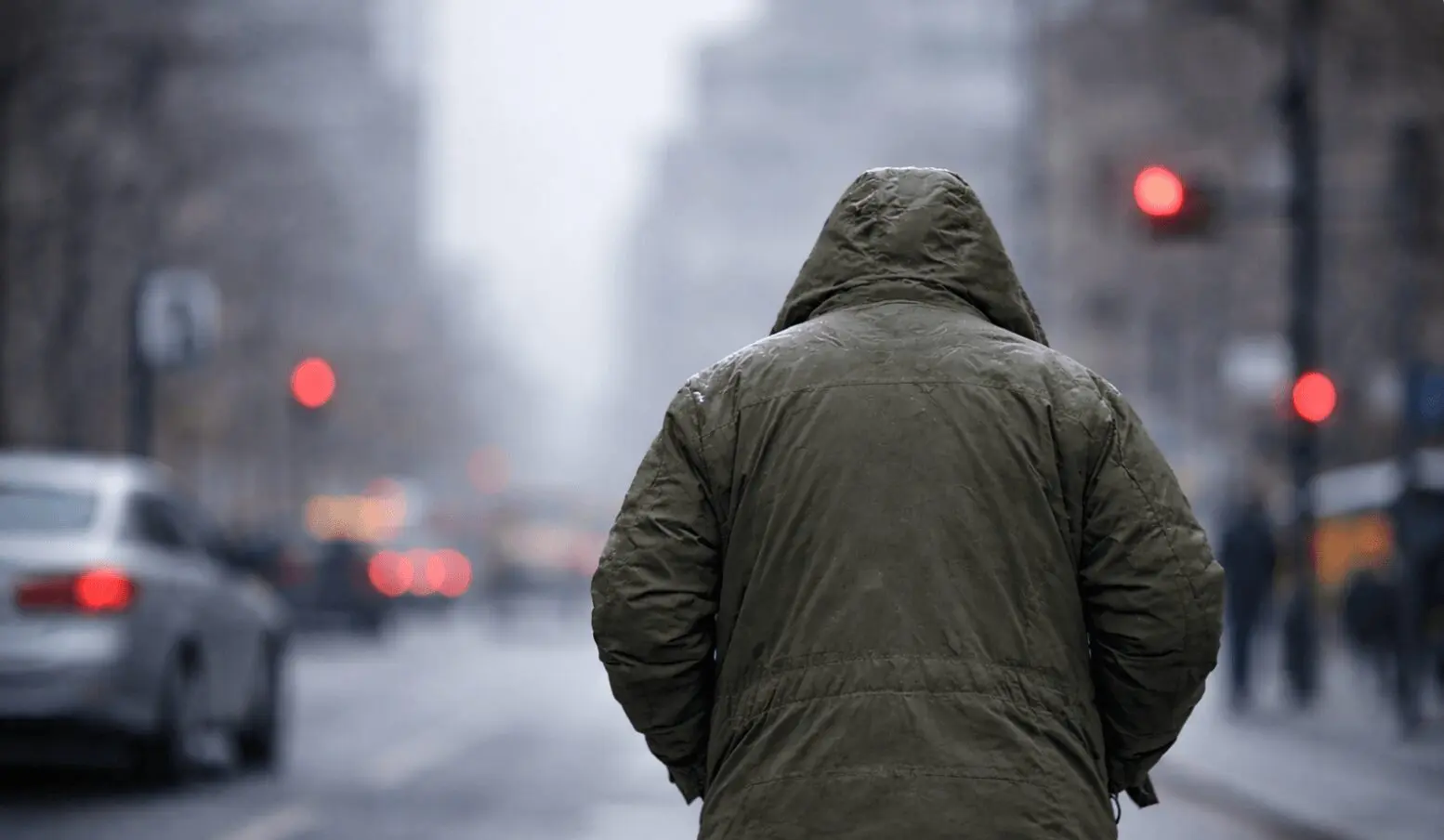 Person in green hooded coat on city street
