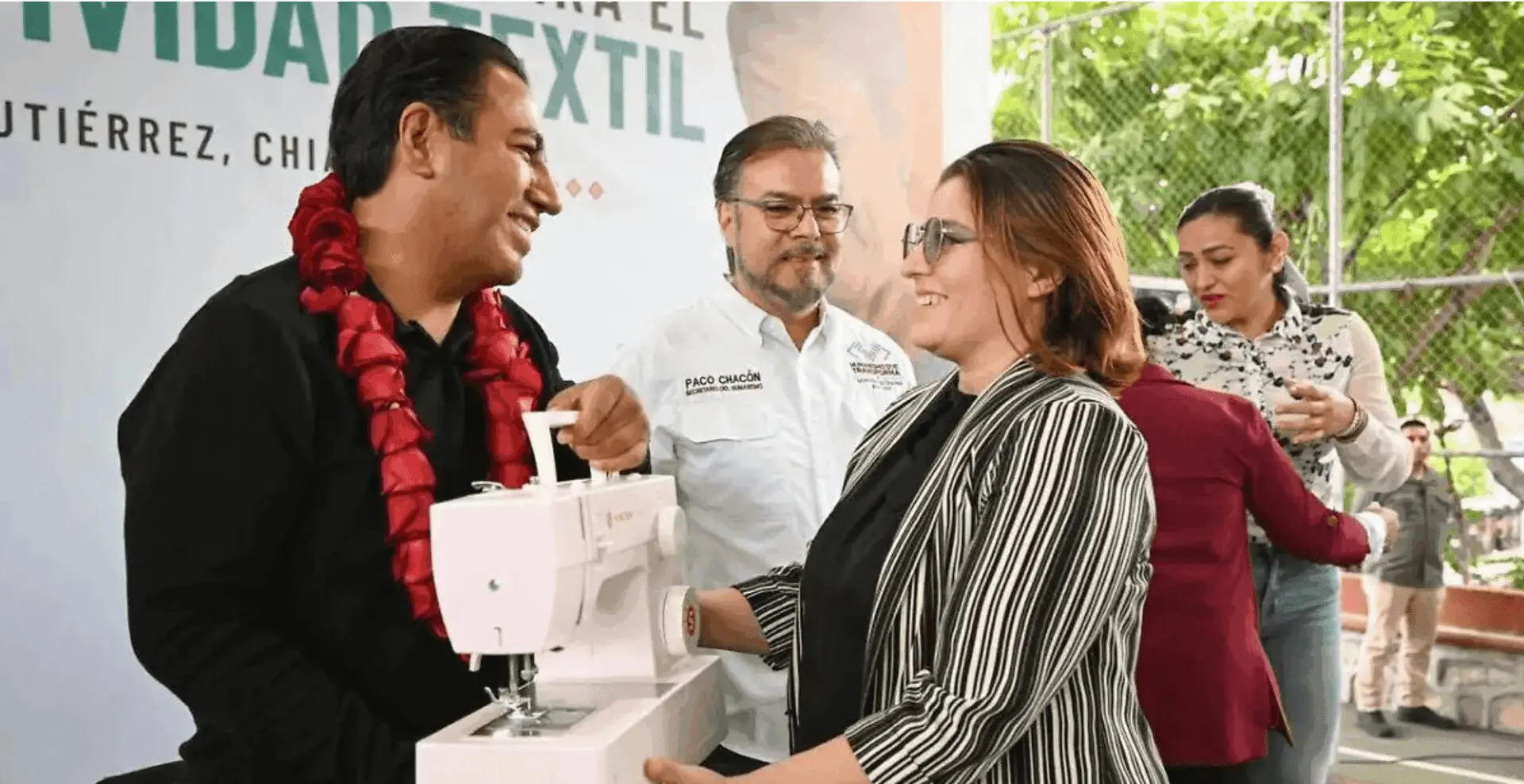 People exchanging sewing machine at community event