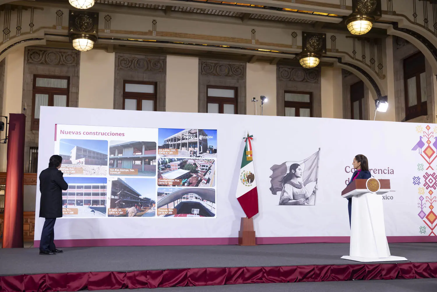 Presenters showcasing construction project images on stage