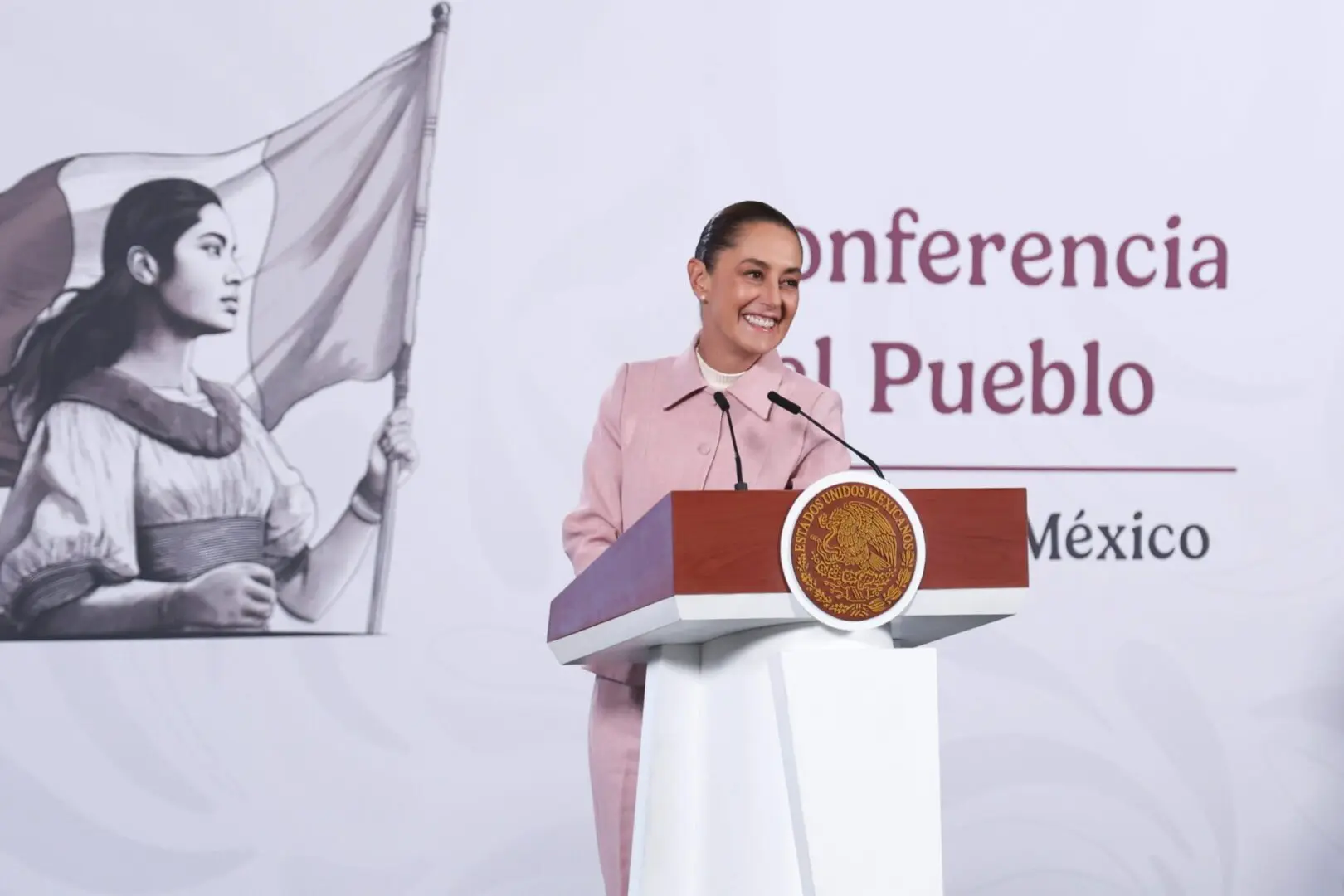 Presidenta de México durante conferencia matutina desde el podio oficial con emblema nacional