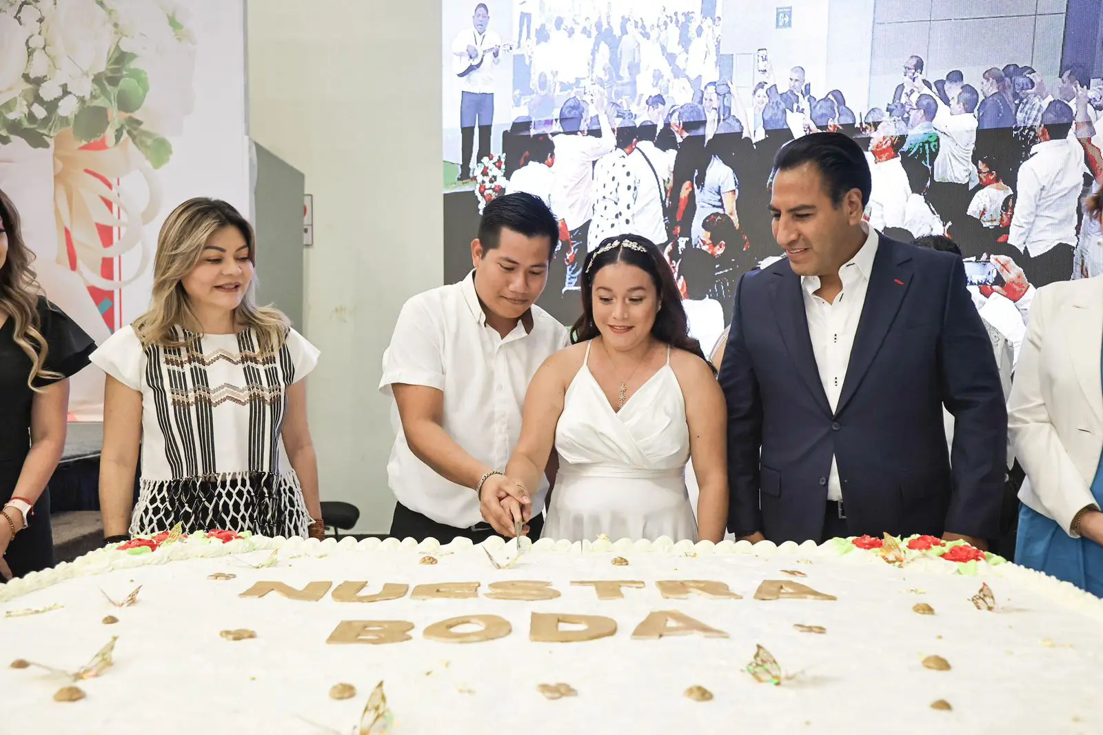 Políticos junto a personas cortando un pastel.