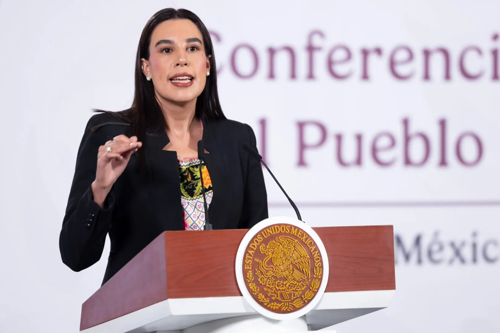 Mujer política hablando en conferencia.