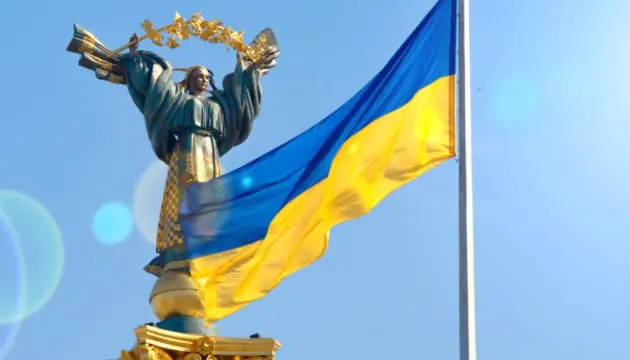 bandera de ucrania frente a monumento con cielo azul