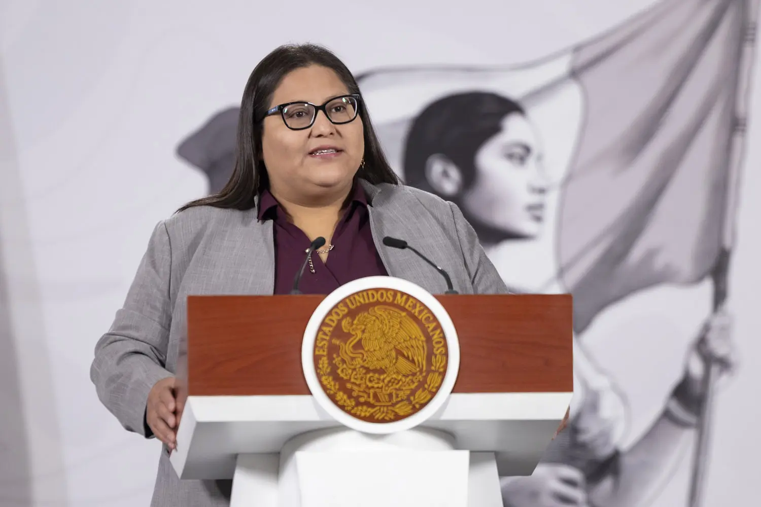 Citlalli Hernández Mora hablando ante micrófono en conferencia de prensa