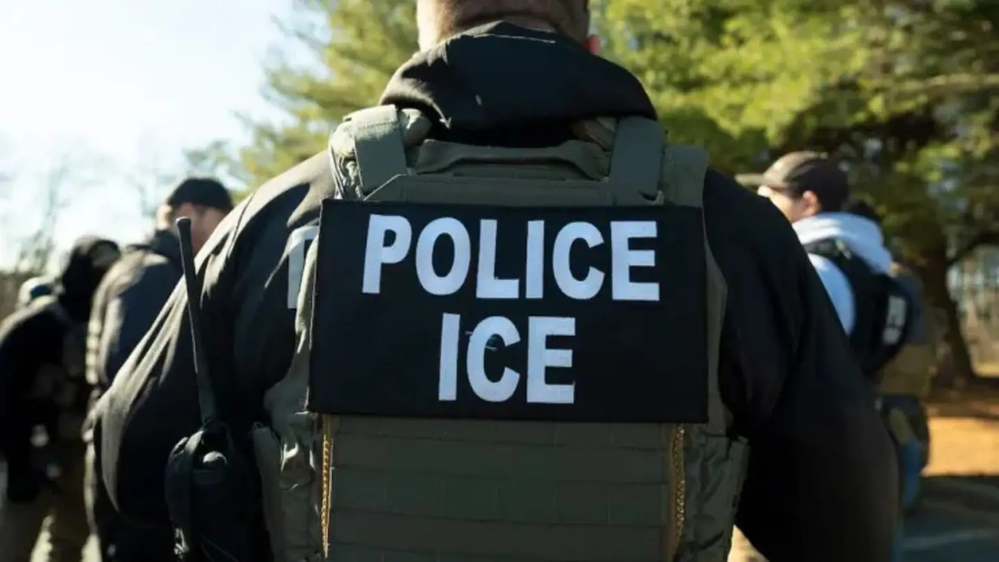 Hombre de espaldas con chaleco de ICE